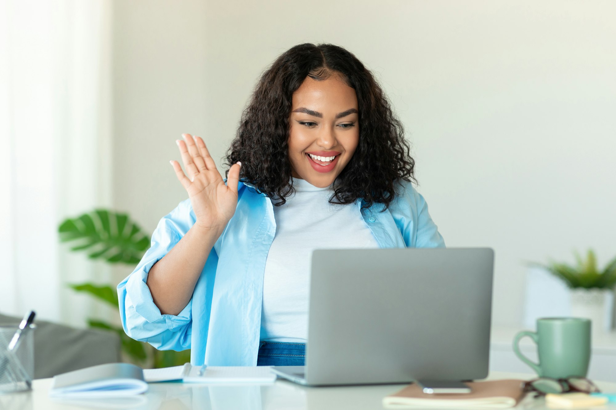 Online meeting concept. Happy black body positive lady using laptop for virtual conferencing, having