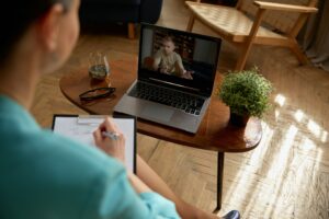 Woman psychologist consulting soldier online holding virtual therapy on laptop