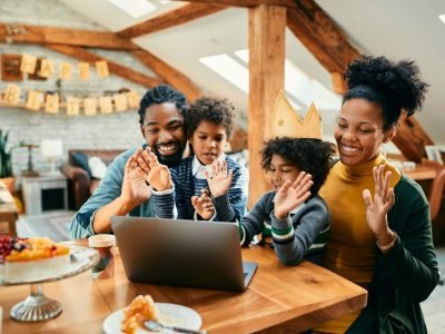 Happy black family making video call during little girl's Birthday party at home.